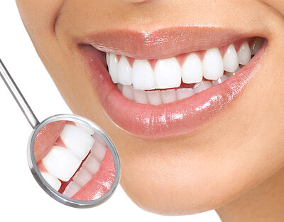 close up image of dental mirror by women's mouth smiling nice white teeth. cosmetic dentistry Durham, NC