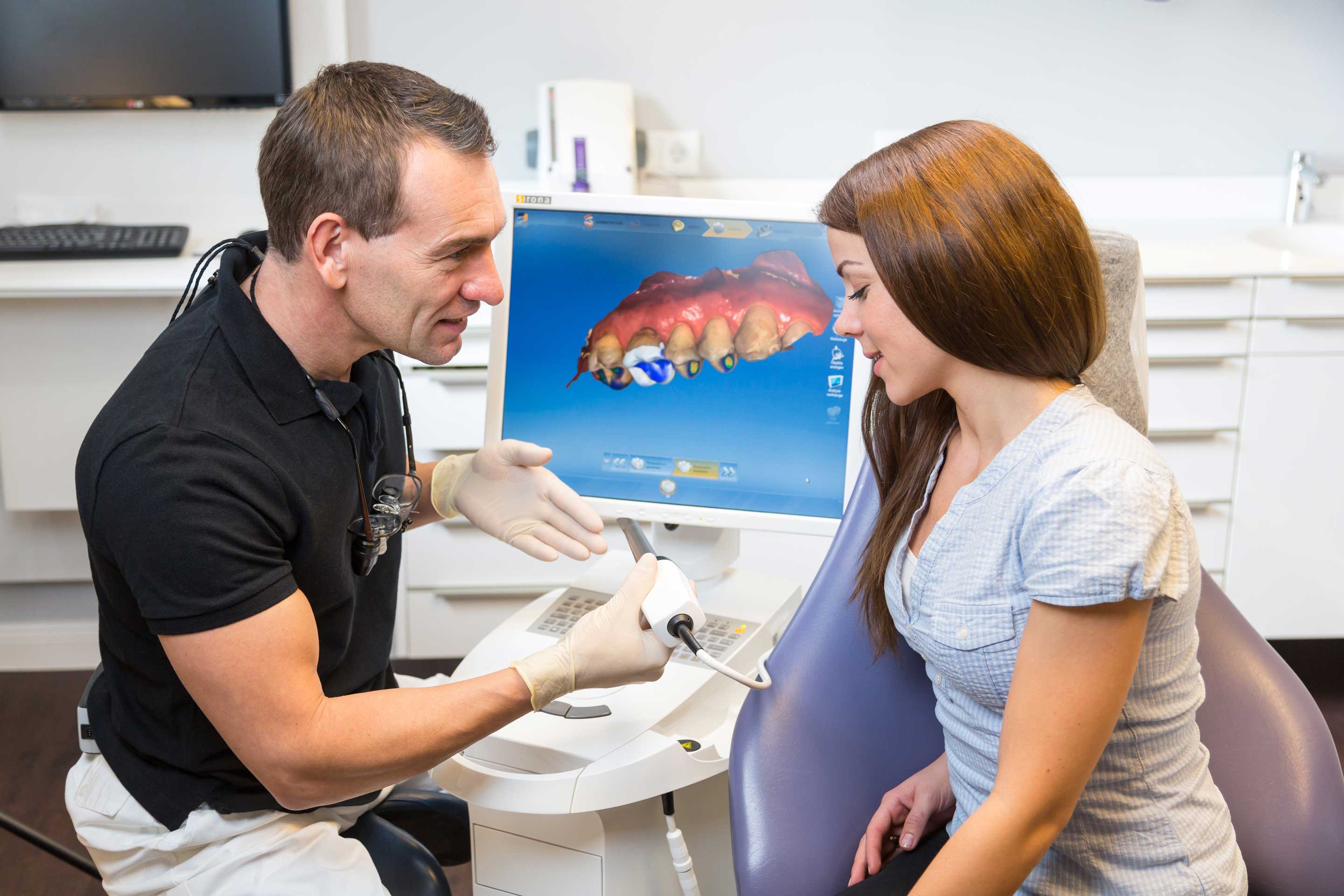 dentist showing female patient CEREC crowns machine, one appointment crowns Durham, NC 